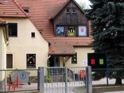 Ein einladendes Familienzentrum mit bunten Fenstern und einem gepflegten Eingangsbereich.