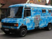 Ein buntes Spielmobil mit Elefantenmotiv parkt auf der Straße und bringt Freude zu Kindern.